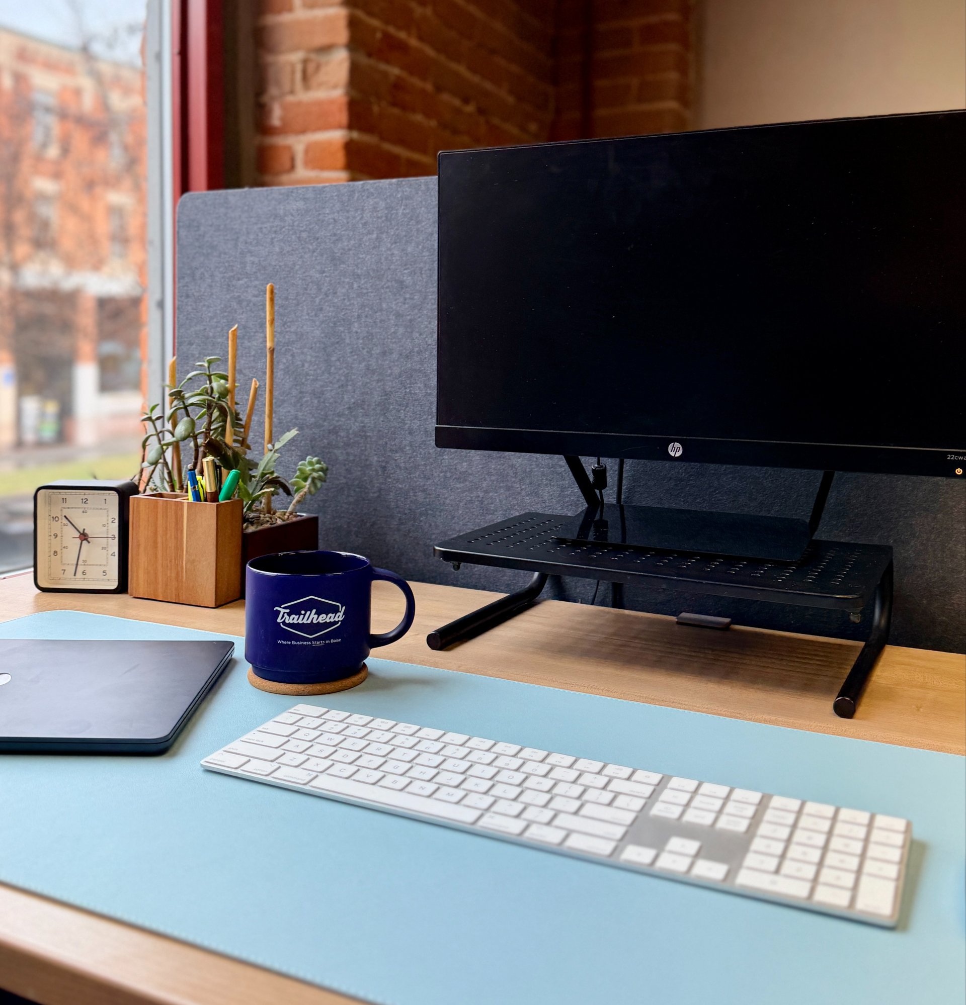 Desktop monitor, keyboard, mug, and other desk accessories